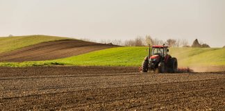 Farmer in tractor preparing land with seedbed cultivator