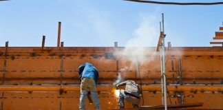 Construction workers welding ship