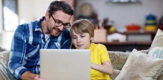 Father helping son on computer