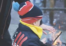 Child outside with campfire