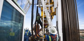 Oil Workers Climb a Rig