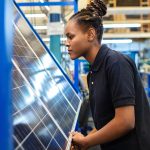 Quality engineer examining solar panels in factory
